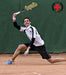 A tennis player wearing a Dr. Arthritis Copper Infused Elbow Compression Sleeve swings their racket at a ball.
