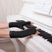 A woman wearing Dr. Arthritis Copper Compression Gloves (Open-Finger) plays the piano.