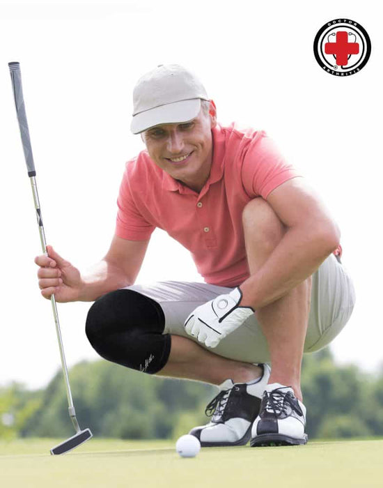 A man crouching down on a golf course wearing a Copper Infused Knee Sleeve by Dr. Arthritis.