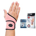 A person wearing a pink Dr. Arthritis Copper Lined Wrist Support on their left hand, with the product packaging and handbook displayed alongside.